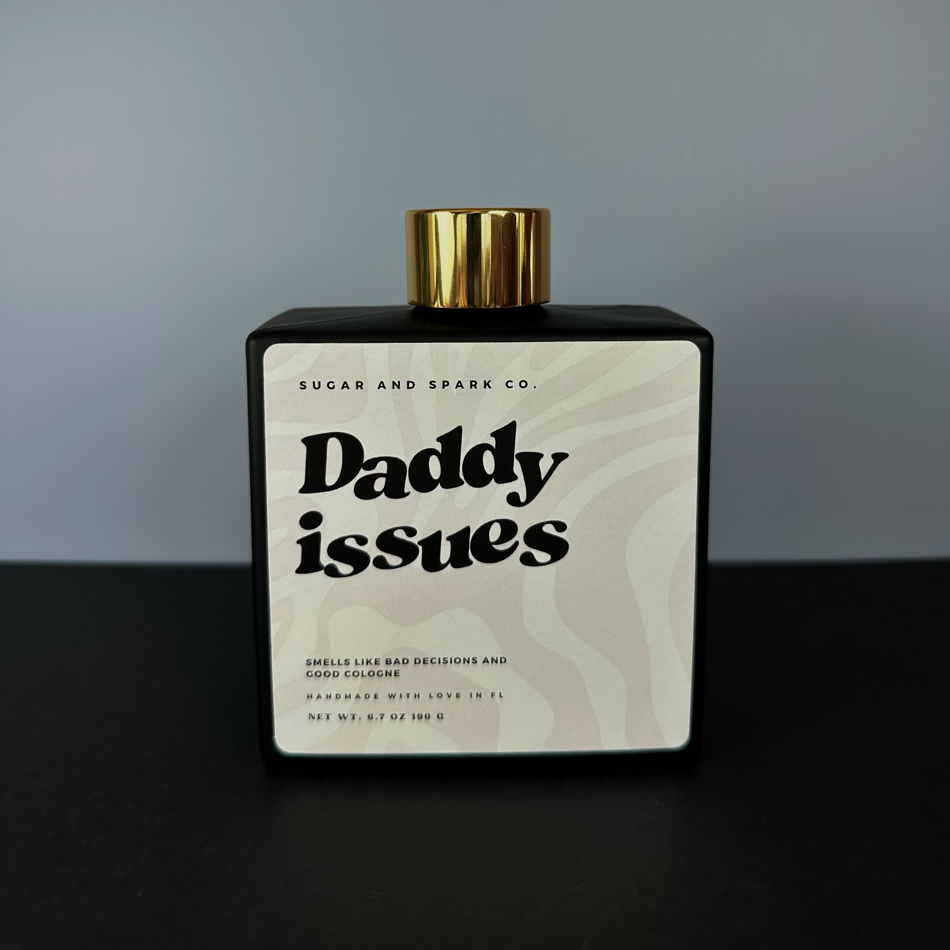 Bottle of 'Daddy Issues' cologne by Sugar and Spark Co. on a gray background