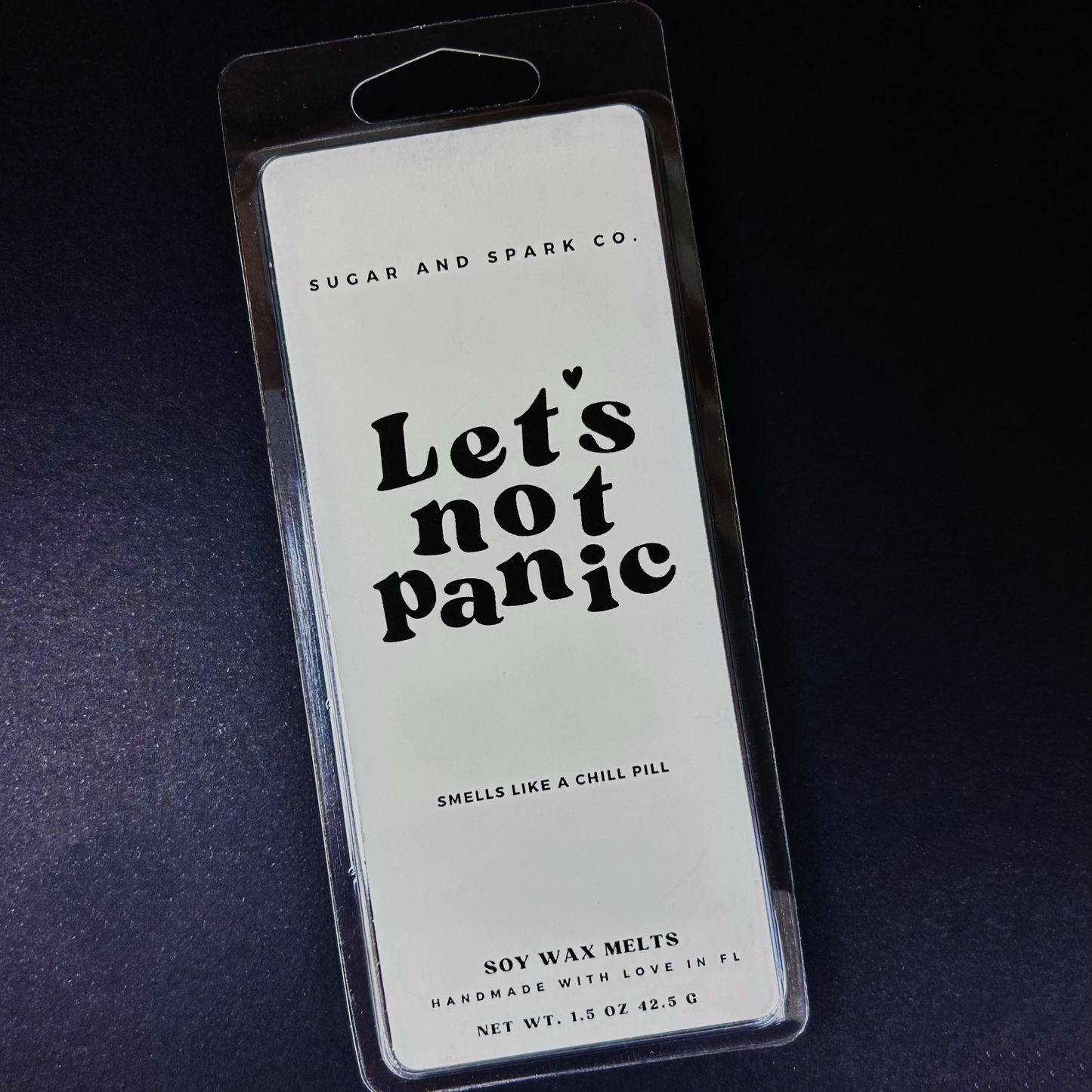 Soy wax melts packaging with 'Let's not Panic' text on a dark background